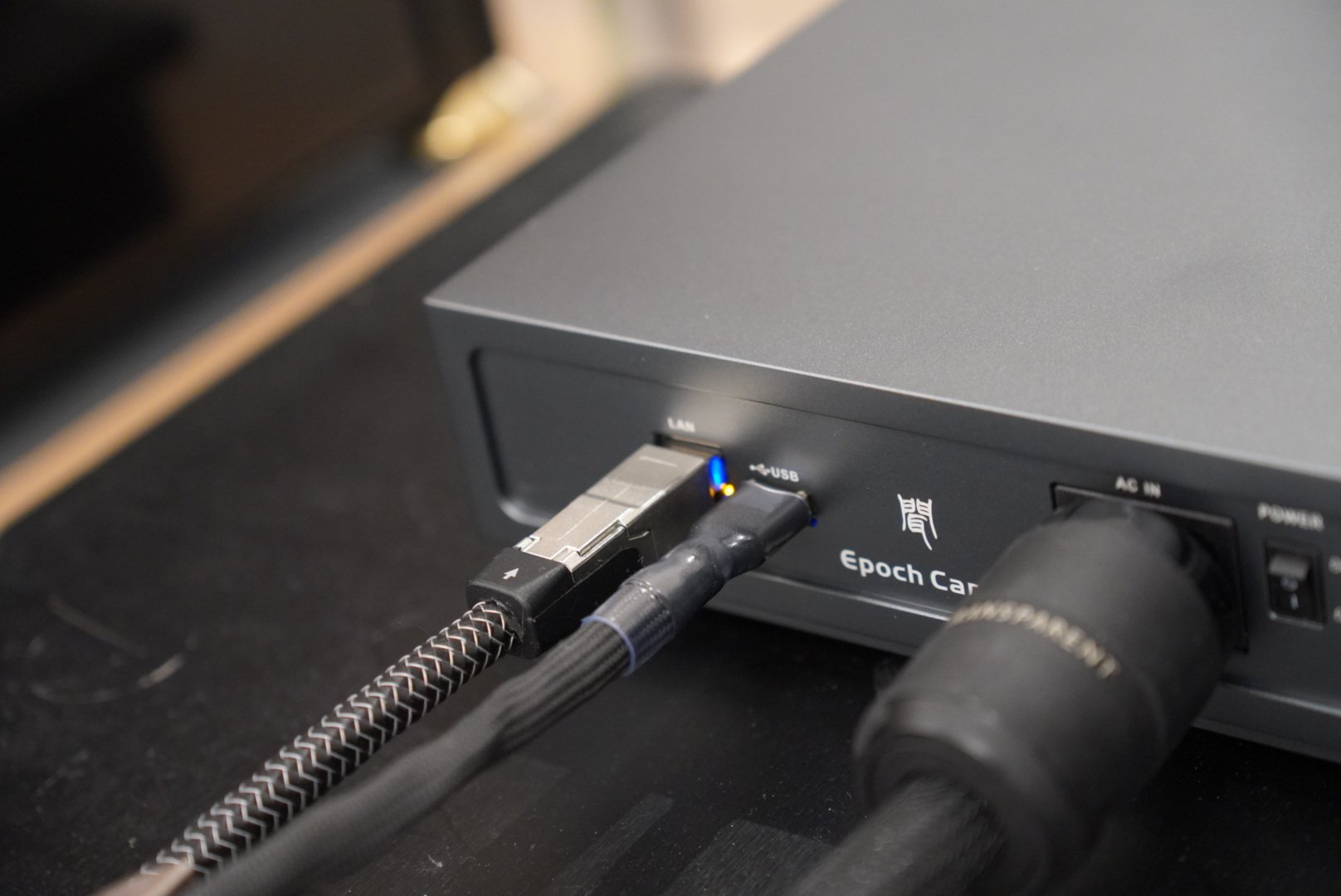 卡农网络桥背部接线实拍：网线与 USB 线接入，蓝色指示灯亮起